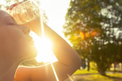 Woman preventing heat stroke by drinking water