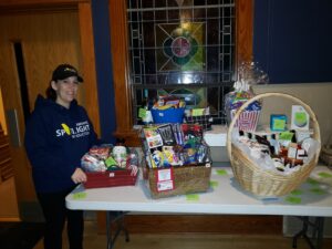 Brigette Finger shows prize baskets in  the ASPI Spotlight Auction